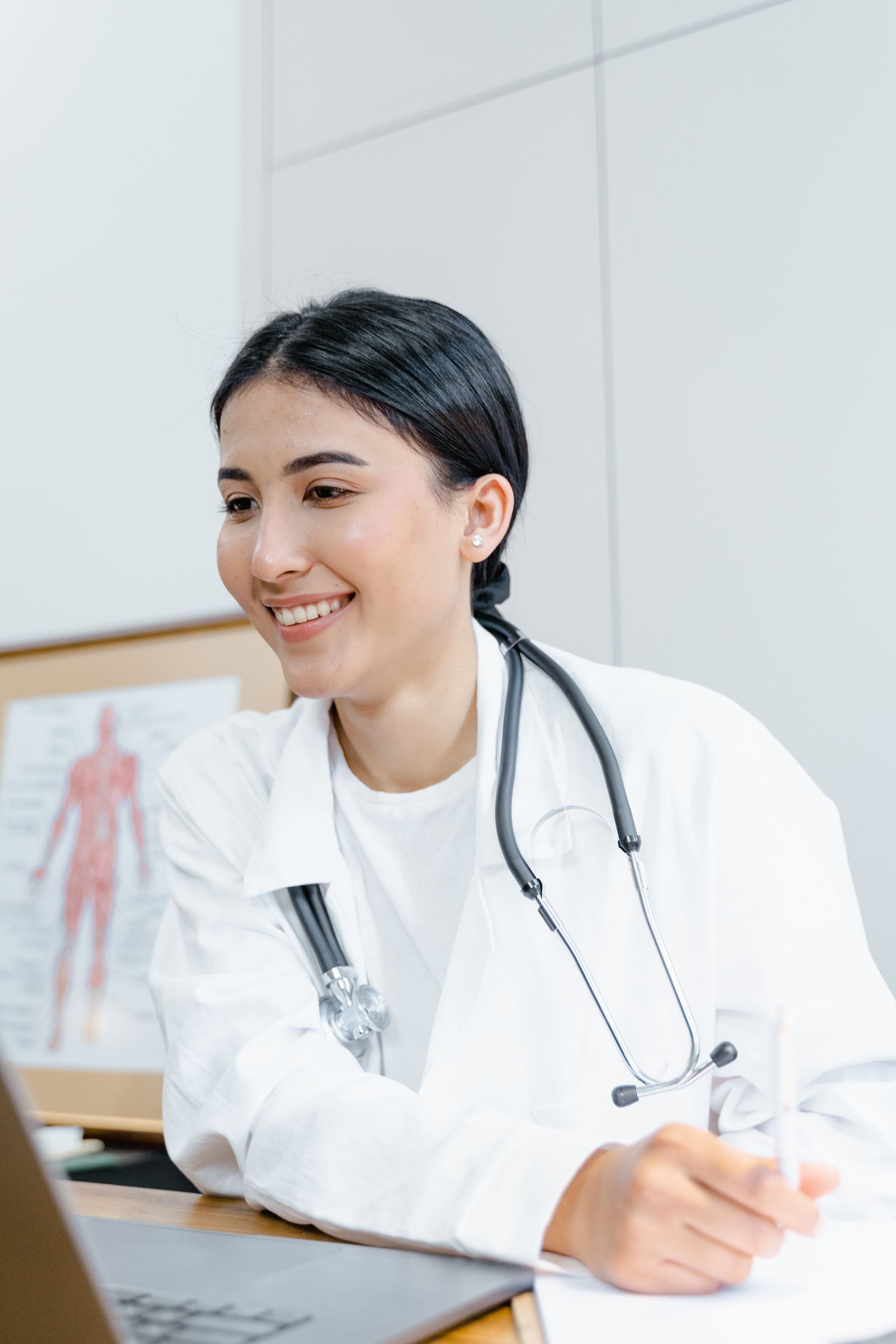 A smiling physician in a white coat