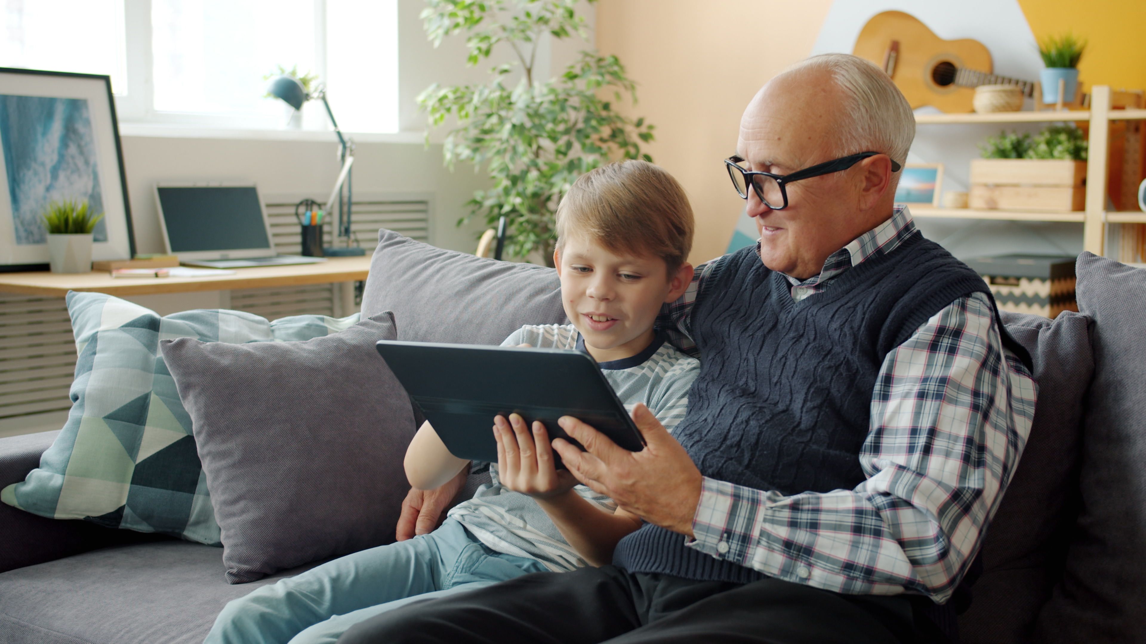 An older patient smiling while reviewing his results on a tablet
