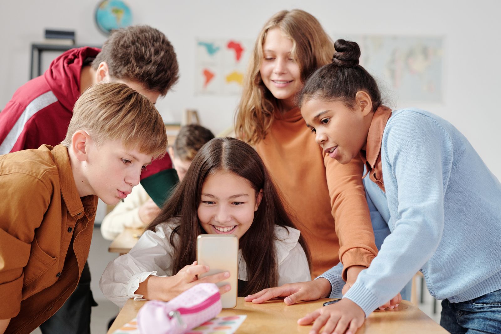 Teenagers smiling together over a smartphone